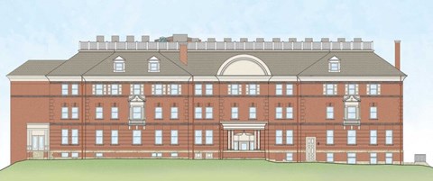 A large red brick building with a central entrance and a balcony on the first floor.