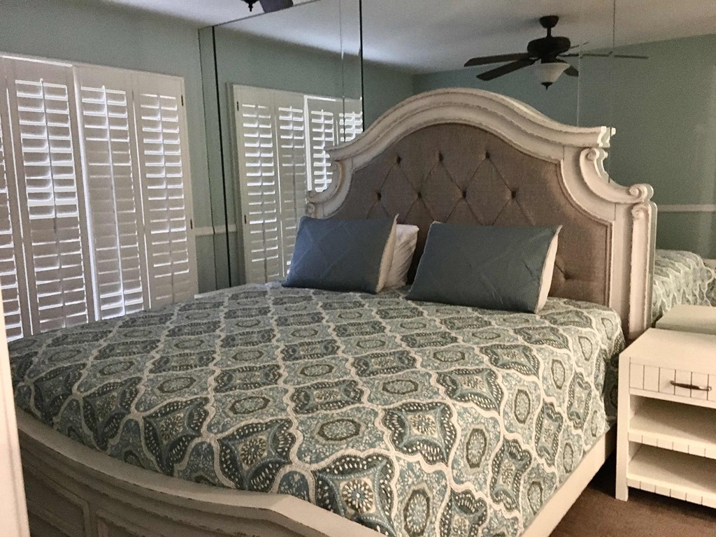 a bedroom with a large bed and a ceiling fan