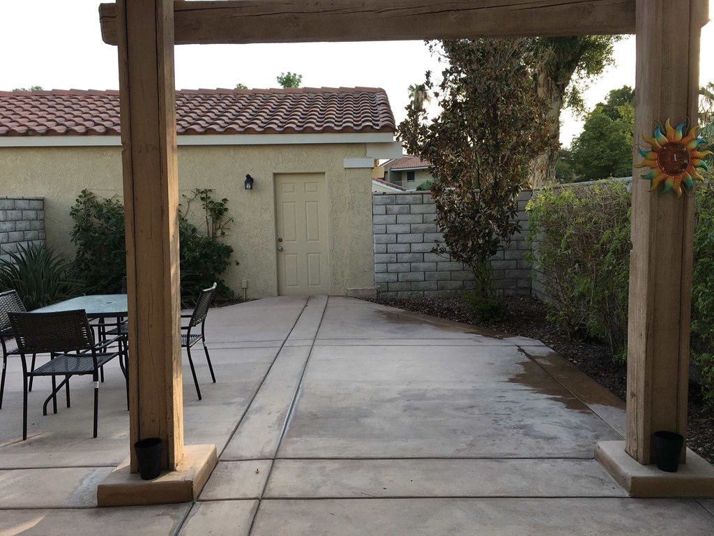 a patio with a gate and a table and chairs