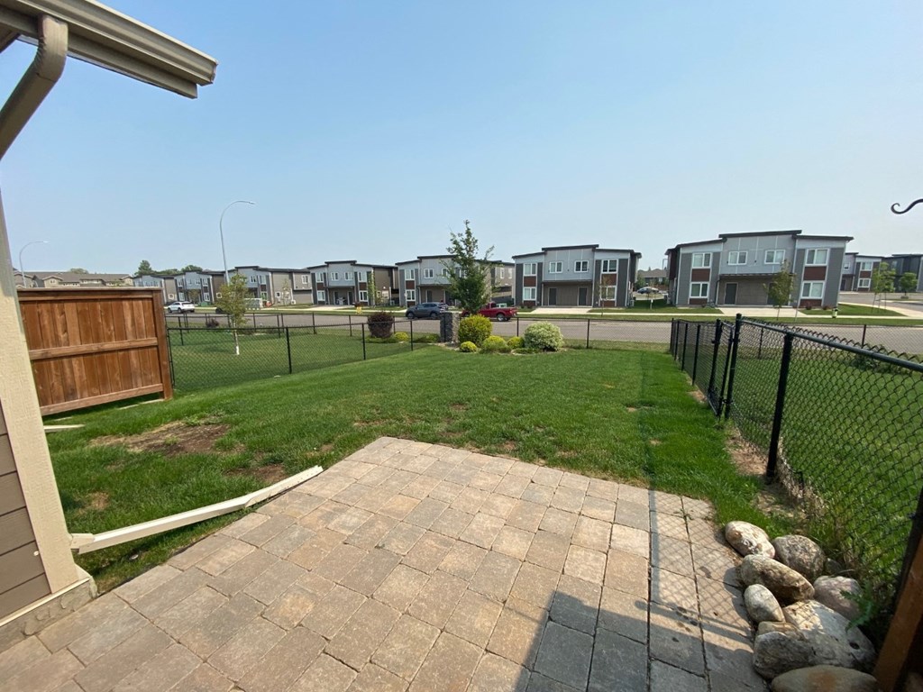 the backyard of a house with a yard and a fence