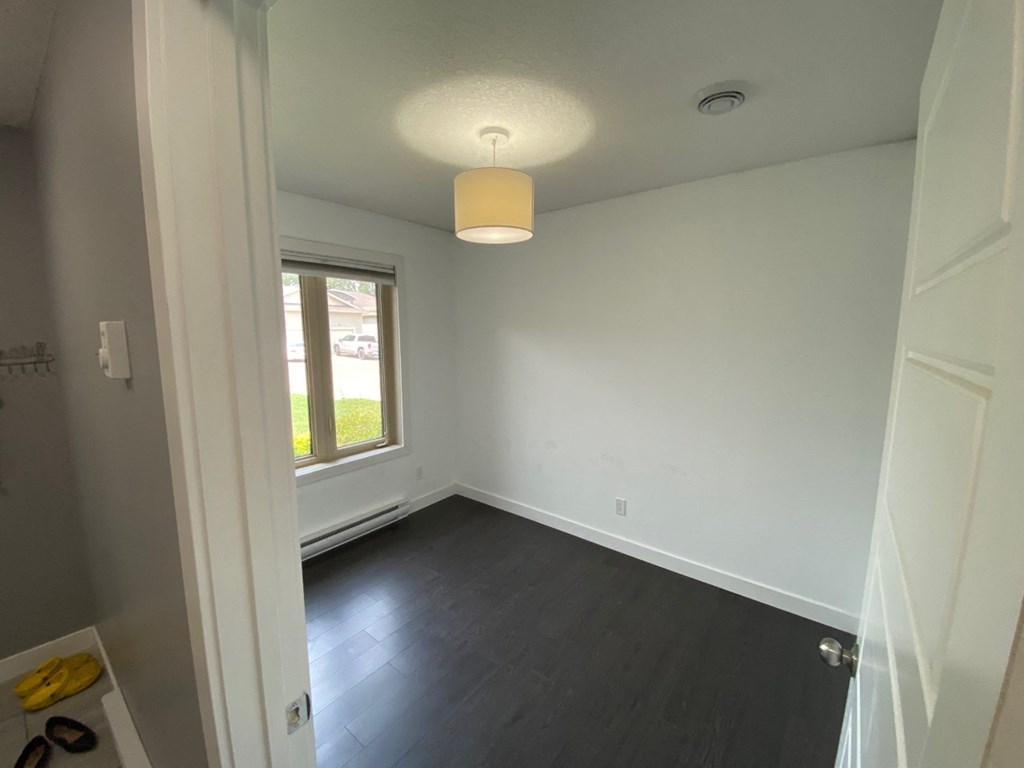 an empty room with white walls and a window