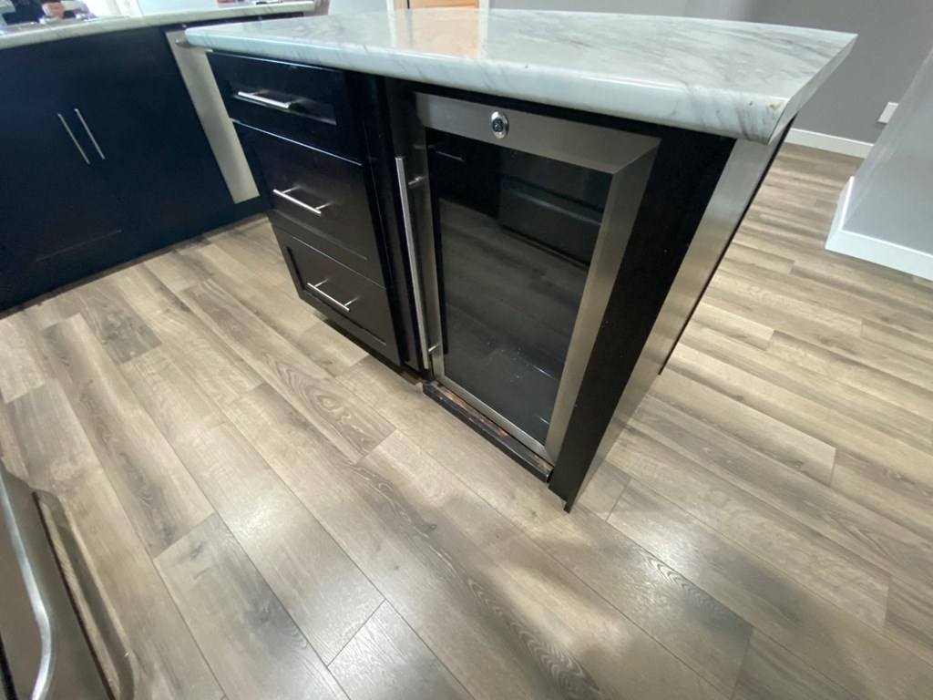 a kitchen with an island with an oven and wooden floors
