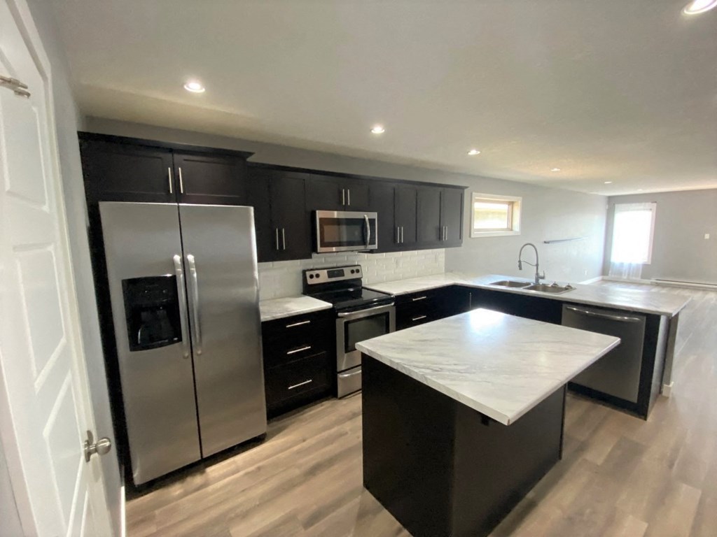 a modern kitchen with stainless steel appliances and black cabinets