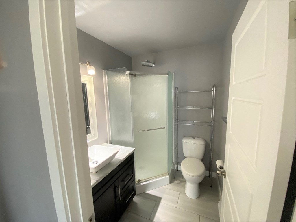 a bathroom with a shower and a sink and a toilet