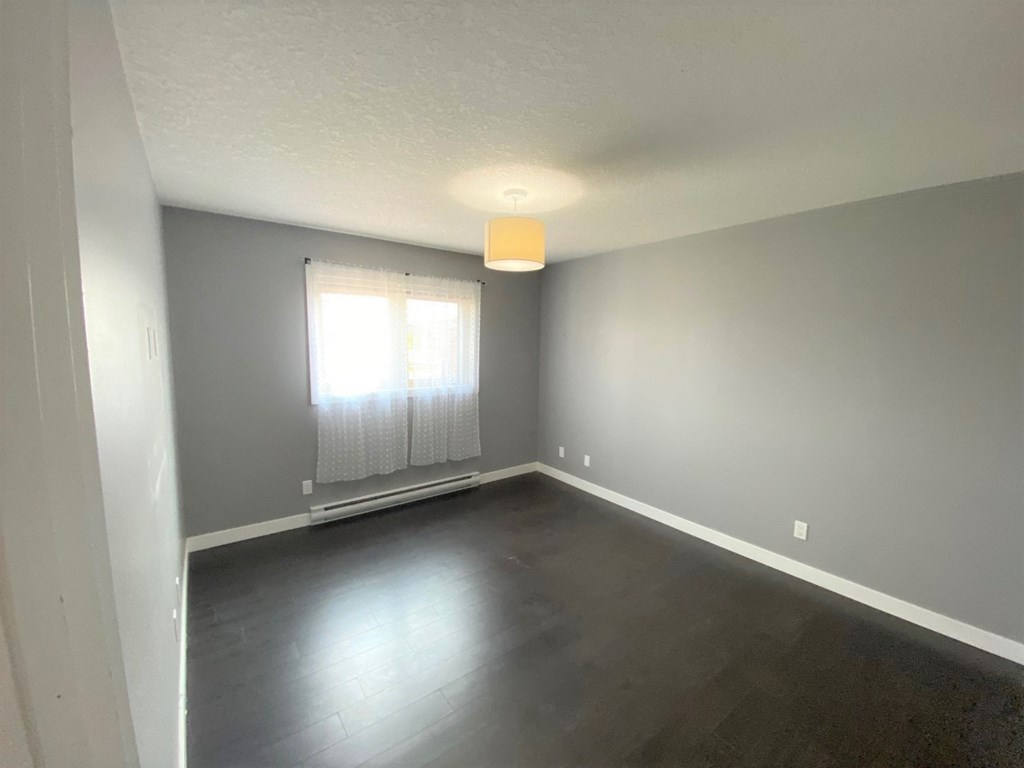 a empty living room with grey walls and a window
