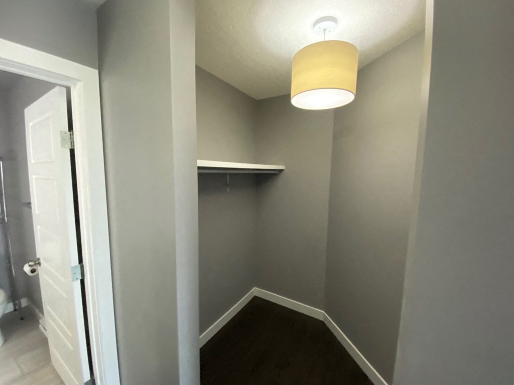 a small hallway with a lamp and a door to a closet