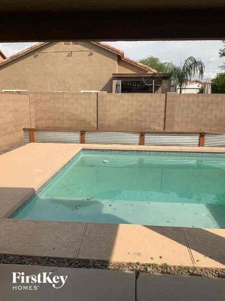 A small pool in a backyard with a FirstKey Homes logo.