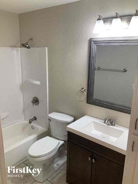 A bathroom with a toilet, sink, and shower.