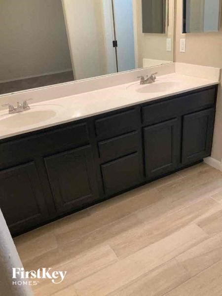 A bathroom with a white countertop and black drawers.