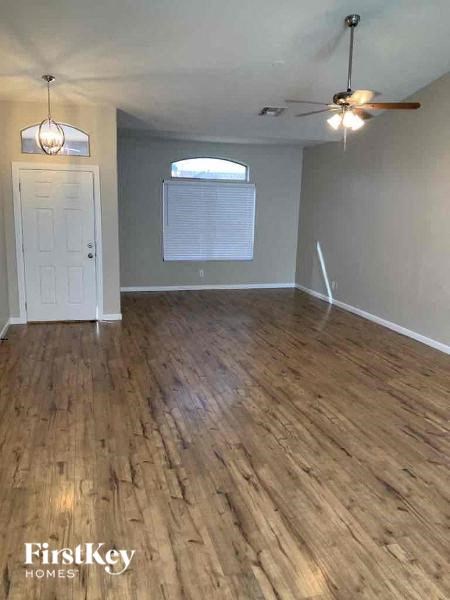 A room with wooden flooring and a ceiling fan.