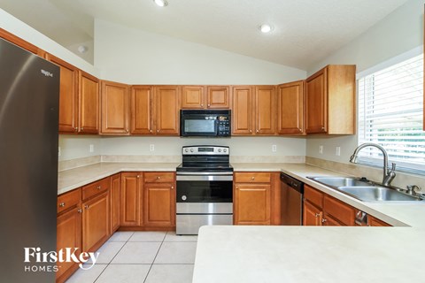 a kitchen with wooden cabinets and stainless steel appliances