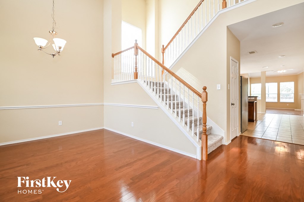 an empty living room with a staircase in a house