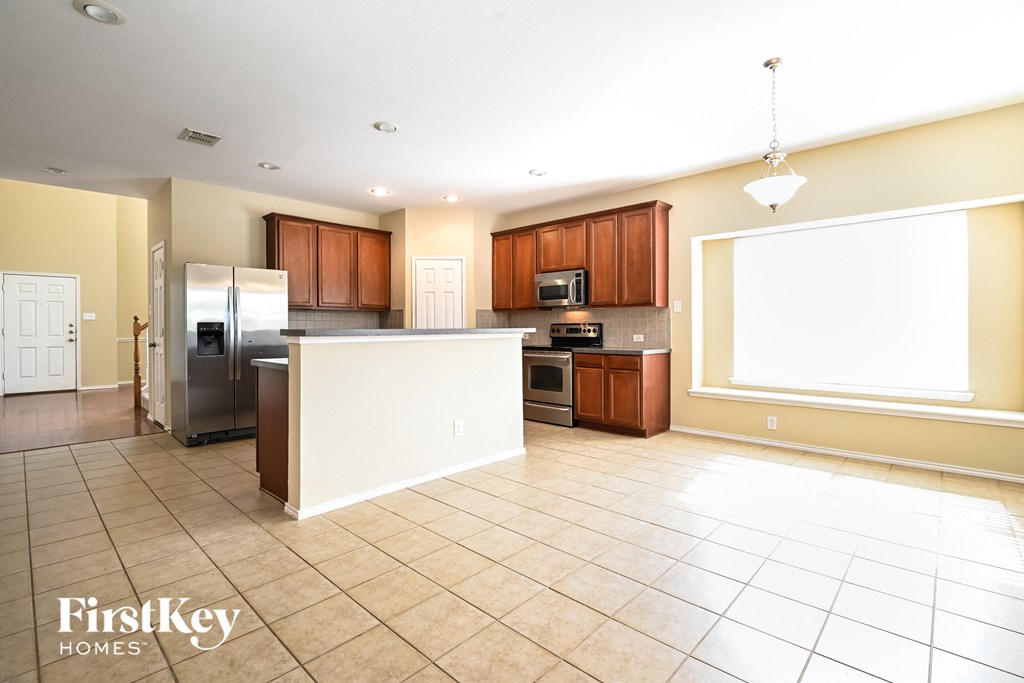 a large kitchen with a white island and stainless steel appliances