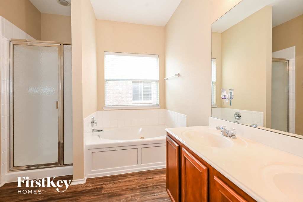 a bathroom with a tub and a sink and a mirror