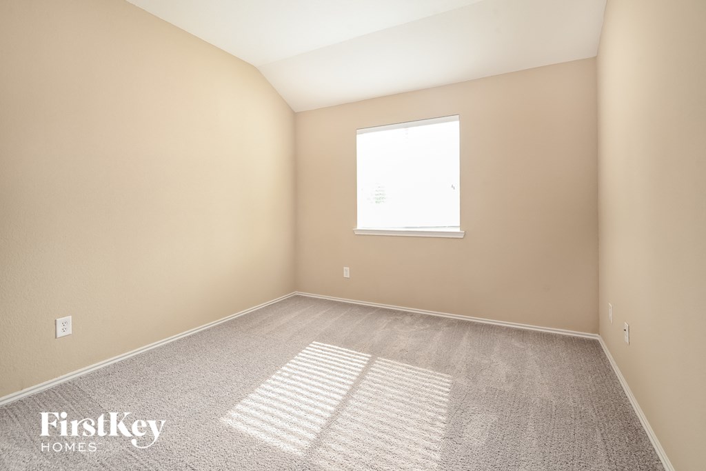 a bedroom with carpet and a window