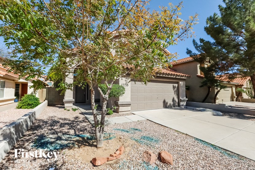 a house with a driveway and a tree in front of it