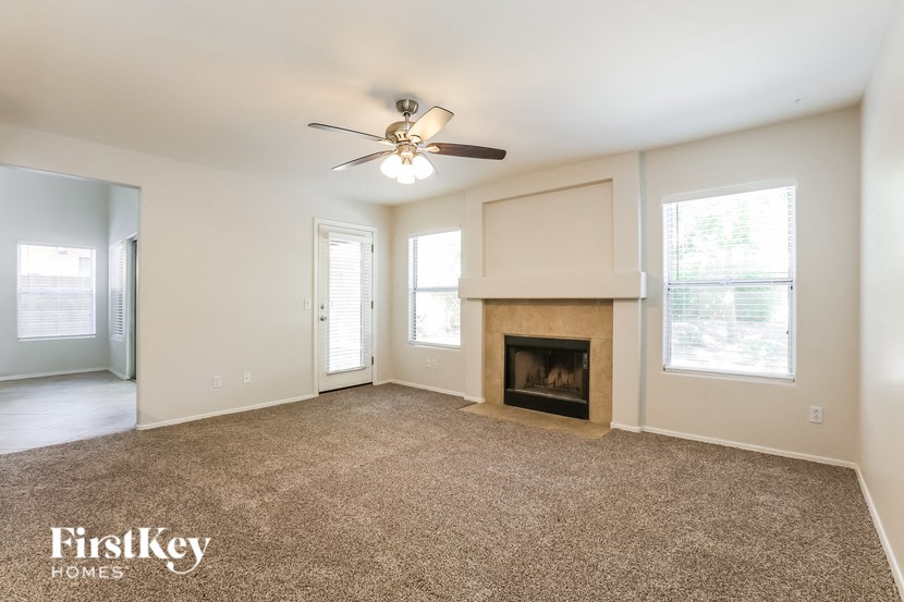 a living room with a fireplace and a ceiling fan