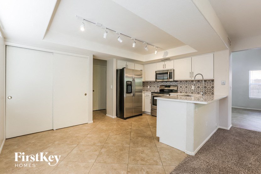 a large kitchen with white cabinets and stainless steel appliances