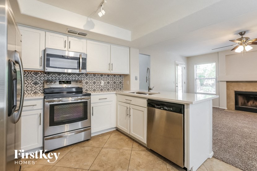 a kitchen with white cabinets and stainless steel appliances