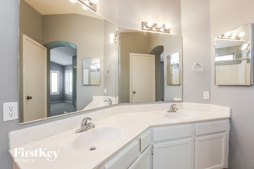 a white bathroom with two sinks and a large mirror