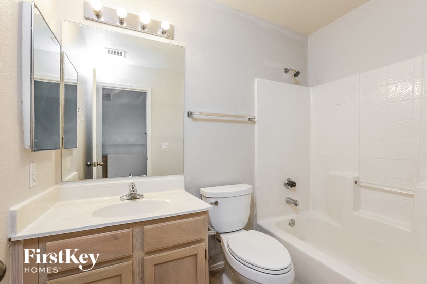 a bathroom with a sink toilet and a mirror