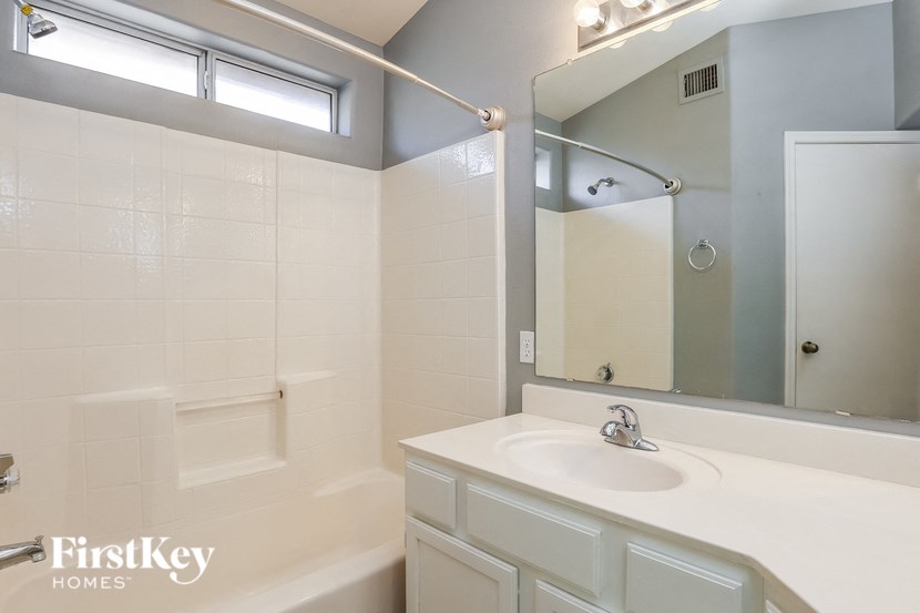 a white bathroom with a sink and a mirror