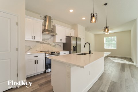 A kitchen with white cabinets and a large island.