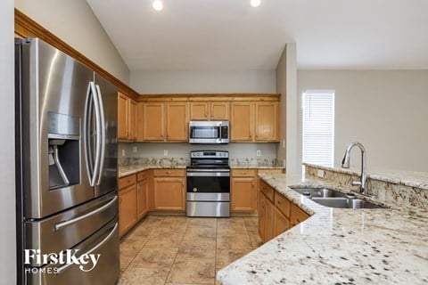 A kitchen with a stainless steel refrigerator and wooden cabinets.