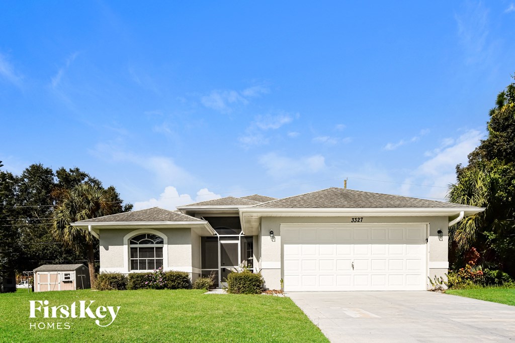 A house with a garage and a driveway in front of it.