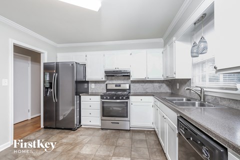 a kitchen with white cabinets and stainless steel appliances