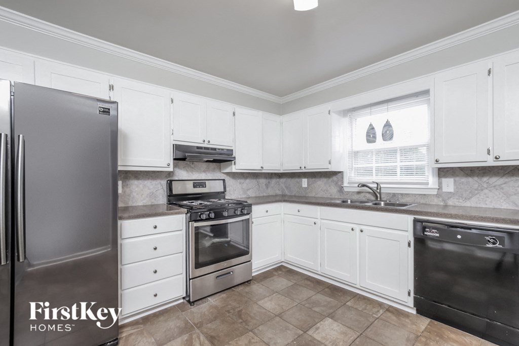 a kitchen with white cabinets and stainless steel appliances