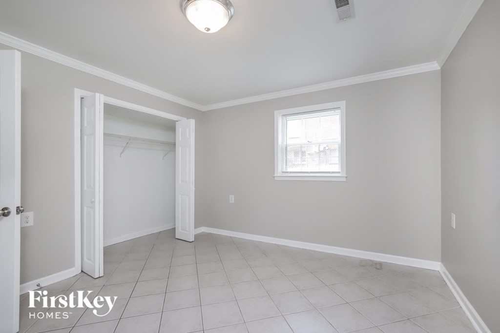 an empty room with a closet and a window