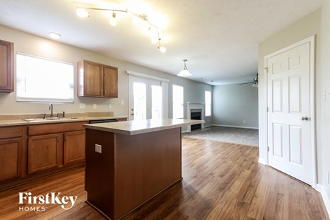 A kitchen with wooden floors and a white door.