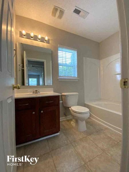 a bathroom with a toilet and a sink and a bath tub