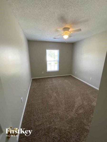 an empty room with a ceiling fan and a window