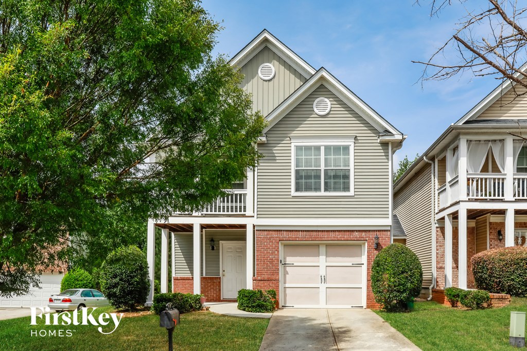 a gray house with a white garage door in front of a lawn