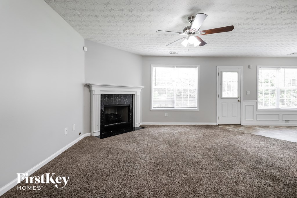 a living room with a fireplace and a ceiling fan