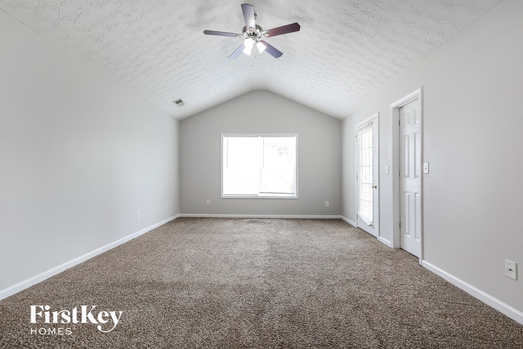 an empty room with a ceiling fan and a window