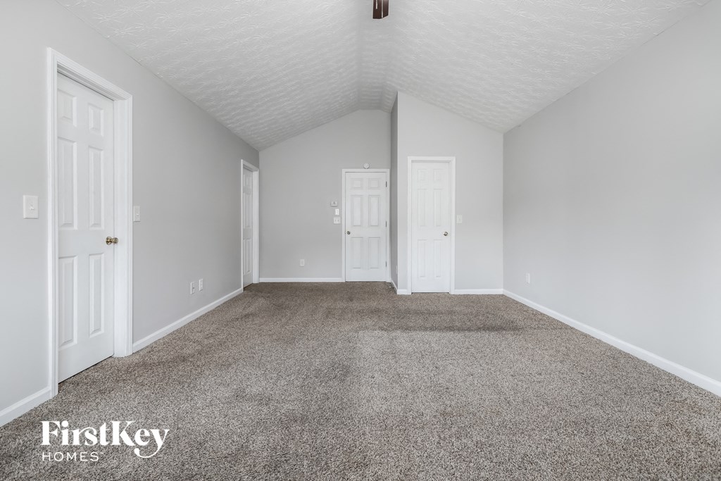 a empty room with carpet and white doors