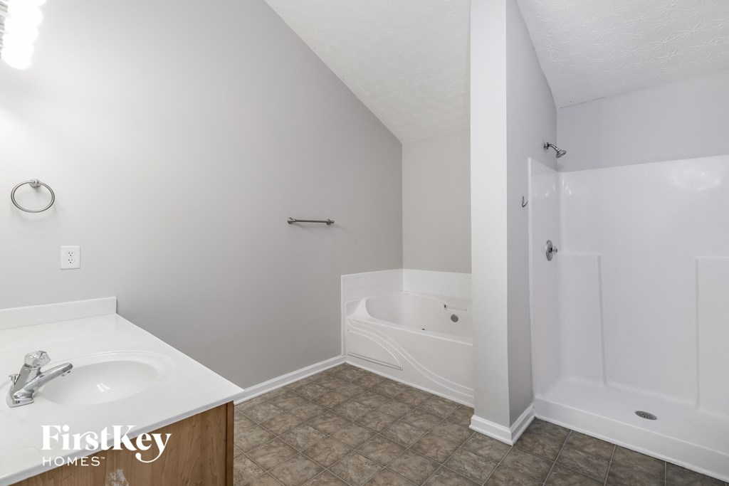 a white bathroom with a tub and a sink