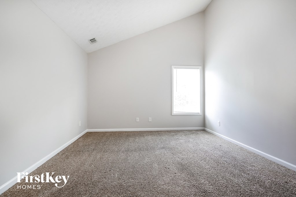 an empty room with white walls and a window