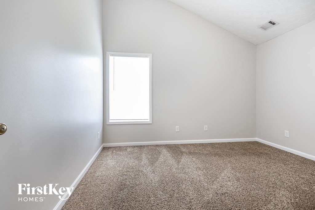 a empty room with carpet and a window