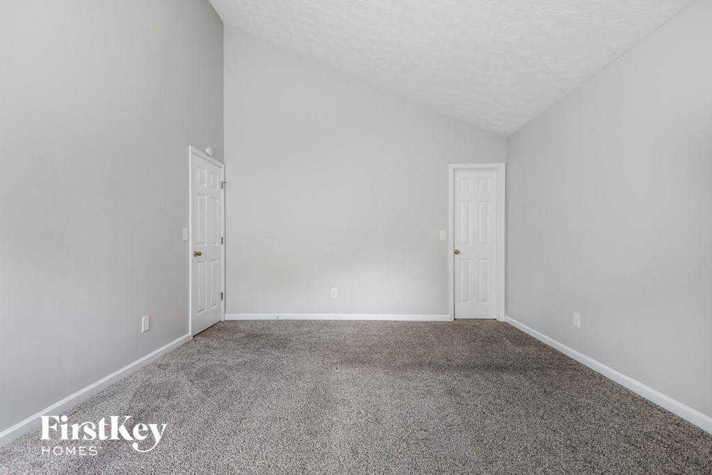 a empty room with carpet and two doors