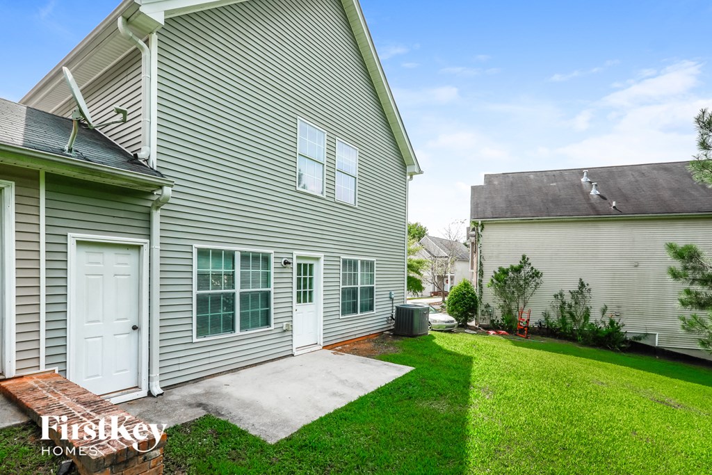 a side view of a house with a yard and a driveway