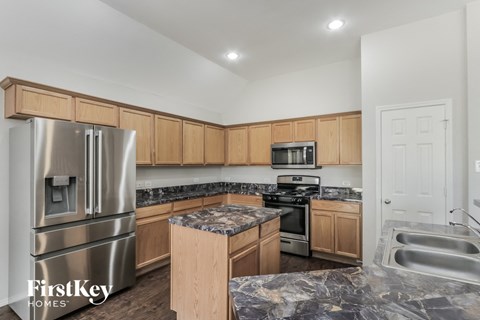 a kitchen with wooden cabinets and stainless steel appliances