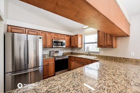 the kitchen is equipped with stainless steel appliances and granite counter tops