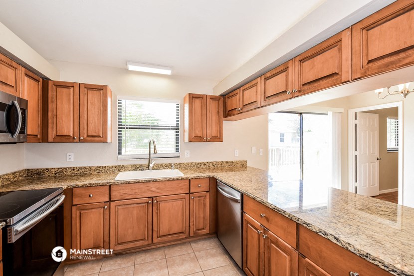 a kitchen with wooden cabinets and granite counter tops and a sink