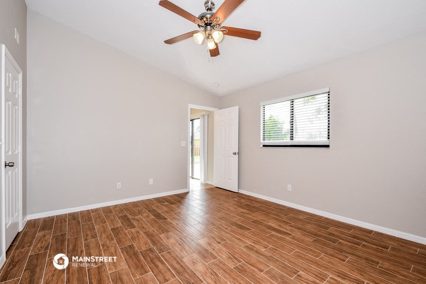 the living room with hardwood floors and a ceiling fan