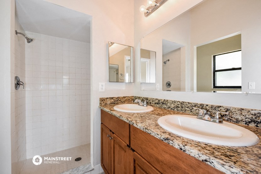 a bathroom with two sinks and a large mirror