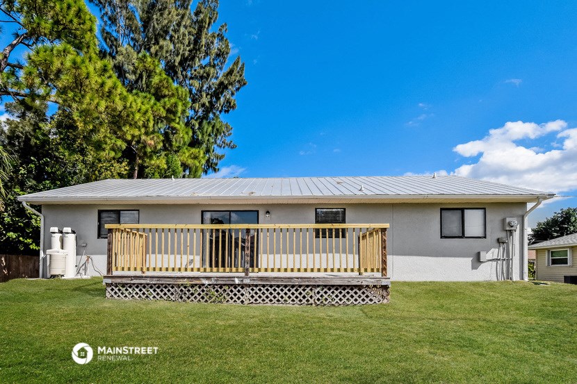 a manufactured home with a deck and a tree